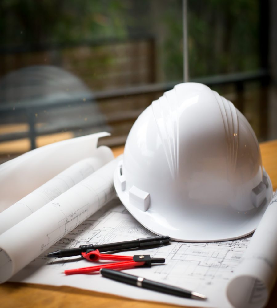 construction concept image helmet rolled blueprints on wooden boards in retro style.